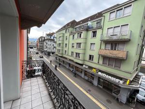 einen Balkon mit Blick auf eine Straße mit Gebäuden in der Unterkunft Gasthaus 210 in Zürich