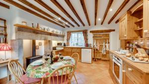 a kitchen with a table and chairs and a kitchen with wooden ceilings at Wharf in Cromford