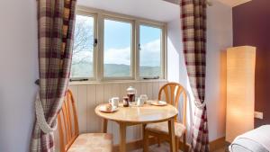 een kleine tafel en stoelen in een kamer met een raam bij Farriers Cottage in Ilam