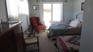 a room with a bedroom with a bed and a chair at Johnson Shore Inn in Harmony Junction