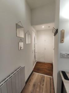 een hal met witte muren en een houten vloer bij Studio Le pigeonnier in Tallard