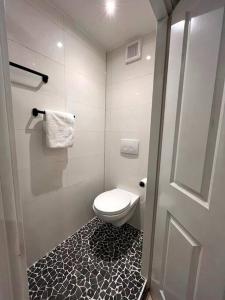 La salle de bains est pourvue de toilettes et d'un sol noir et blanc. dans l'établissement Gezellig appartement, Gerenoveerd eind 2022, à Tilbourg