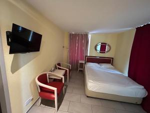 ein Hotelzimmer mit einem Bett und einem TV in der Unterkunft Gasthaus 210 in Zürich