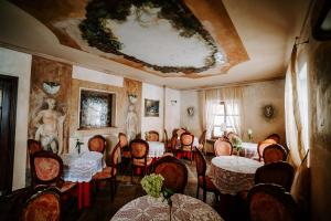 comedor con mesas y sillas y una pintura en el techo en Hotel Senator, en Zamość