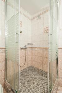 baño con ducha y puerta de cristal en Alkiones, en Plati