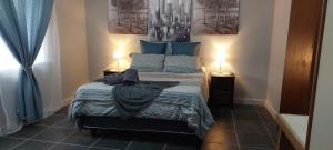 a bedroom with a bed with blue pillows at M&J inn in Kimberley