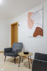ein Wohnzimmer mit 2 Stühlen und einem Tisch in der Unterkunft DD Boutique Apartments in Cluj-Napoca