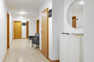 einen Flur mit einem Zimmer mit Stuhl und Spiegel in der Unterkunft DD Boutique Apartments in Cluj-Napoca