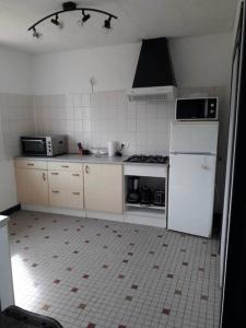 a kitchen with a white refrigerator and a stove at Gite Au Marianne in Jû-Belloc