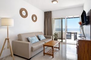 a living room with a couch and a view of the ocean at Callao Beach 3 in Arrieta