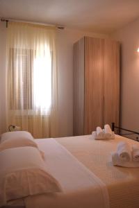 een slaapkamer met 2 bedden en handdoeken bij Le Mimose in Pulsano