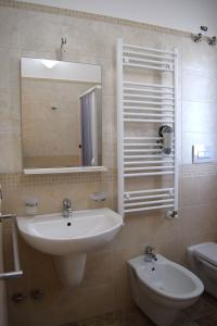 een badkamer met een wastafel, een spiegel en een toilet bij Le Mimose in Pulsano