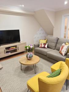 un soggiorno con divano e TV di A casiña de Estela a Caldas de Reis