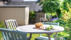 a table with glasses of wine and a plate of fruit at Hope Cottage in Brassington