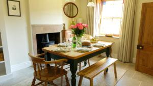a dining room table with a vase of flowers on it at Hope Cottage in Brassington