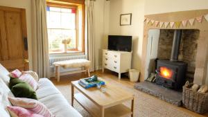 a living room with a couch and a fireplace at Hope Cottage in Brassington