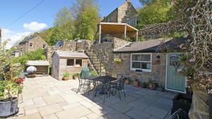 a patio with a table and chairs and a building at Springbank in Two Dales