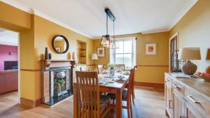 a dining room with a table and a fireplace at Springbank in Two Dales