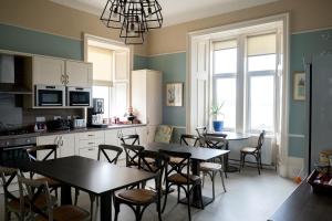 a kitchen with tables and chairs in a room at Corran House Guest House in Oban
