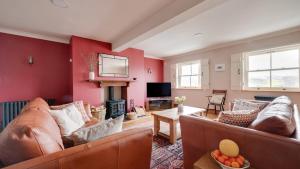 a living room with red walls and leather couches at Springbank in Two Dales