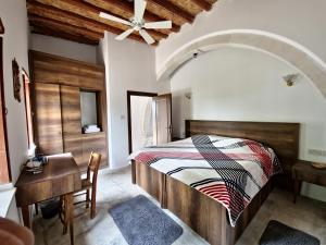 ein Schlafzimmer mit einem Bett, einem Tisch und einem Schreibtisch in der Unterkunft Cyprus Village House in Kyrenia