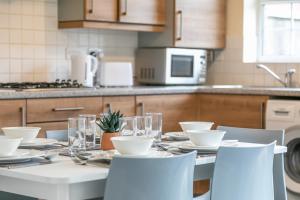 a kitchen with a table with plates and glasses on it at Durham Heights in Leyland
