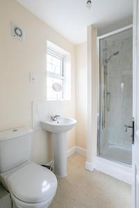a bathroom with a toilet and a sink and a shower at Durham Heights in Leyland
