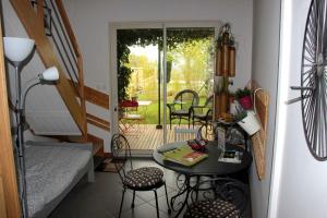ein kleines Wohnzimmer mit einem Tisch und Stühlen in der Unterkunft LA TUILIERE in Mutigny