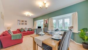 a living room with a table and a red couch at Stanton Lodge Cottage in Curbar