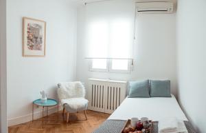 a small bedroom with a bed and a chair at My City Home - Amplio apartamento en Salamanca in Madrid