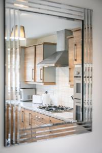 a kitchen with wooden cabinets and a stove top oven at Durham Heights in Leyland