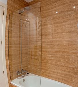 a bathroom with a shower with a white tub at My City Home - Amplio apartamento en Salamanca in Madrid