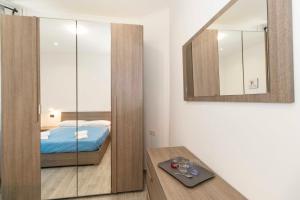 a bedroom with a bed and a mirror and a table at Lingotto Fair Comfy Apartment x4 - MM Italia 61 in Turin