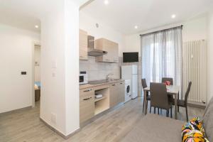 a kitchen and dining room with a table and a dining room at Lingotto Fair Comfy Apartment x4 - MM Italia 61 in Turin