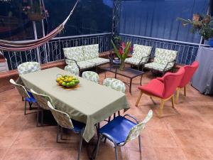 - une table, des chaises et une corbeille de fruits sur la terrasse dans l'établissement Cabaña Campestre Las Palmas, à Pereira
