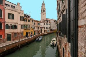Ein Kanal in einer Stadt mit Booten. in der Unterkunft Cà Regina Panada - passion on the Canal in Venedig