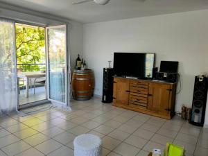 a living room with a flat screen tv and a table at Au pied des calanques, nature, plages à 6min, parking, bus direct, idéal famille in Marseille
