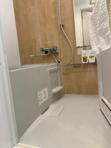 uma casa de banho com um chuveiro com a porta aberta em ONE STAGE HOTEL em Tóquio
