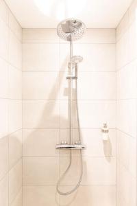a shower with a shower head in a bathroom at L'Olympe - Résidence Hestia in Saint-Étienne
