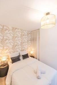 1 dormitorio con 1 cama blanca y 2 almohadas en L'Olympe - Résidence Hestia en Saint-Étienne
