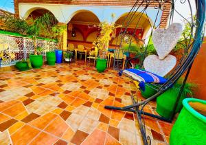a patio with plants and chairs on a tiled floor at Riad Maison Aicha in Marrakesh