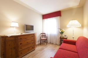 a living room with a red couch and a television at La Perla Apartment in Verona