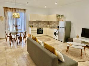 a kitchen and living room with a couch and a table at Cute & sweet home in Archangelos