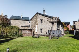 a stone house with two benches in a yard at Xalet Montana in Ur