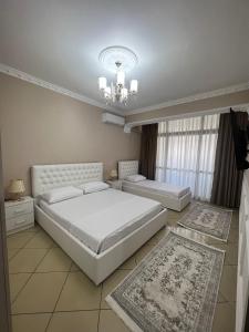 a bedroom with two beds and a chandelier at SaEl Apartments in Shkodër