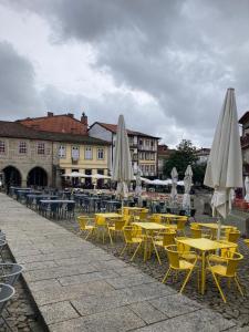 a group of tables and chairs with umbrellas at Hospedaria Cidade Berço in Guimarães
