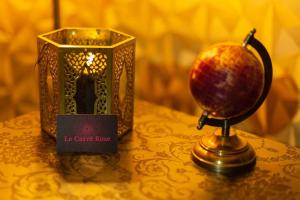 a candle box and a lamp on a table at Le Carré Rose - Love Room proche de Rennes in Guichen +6 photos