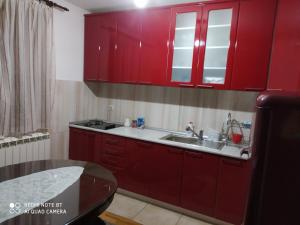 a kitchen with red cabinets and a sink at Domaćinska kuća in Arandjelovac