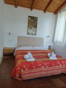 1 dormitorio con 1 cama con colcha roja en Villette Monte Alto, en Patti