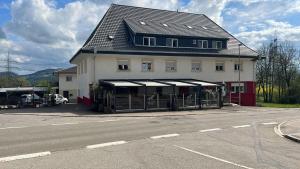 a large white building with a black roof on a street at Era Home in Murg